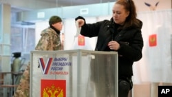 A woman casts her ballot at a polling station in St. Petersburg on March 15.