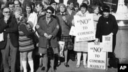 Demonstranți contra Pieței Comune în fața Camerei Comunelor de la Londra, 28 octombrie 1971. Pe 31 ianuarie 2020, Marea Britanie a părăsit Uniunea Europeană (moștenitoarea Pieței Comune), după ce în 2016, 52% dintre britanici au votat pentru Brexit. 