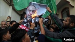 Газа секторундагы палестиндер Авигдор Либерман кызматтан кеткенин жарыялагандан кийин анын сүрөтүн өрттөп жаткан учур. 