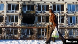 A woman walks past a private hospital hit that was hit in a Russian drone attack on Kyiv on January 5. 