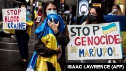 A woman, her baby swaddled in a Ukrainian flag, joined a protest in Hong Kong on March 24 to mark one month since Russia's invasion of Ukraine.