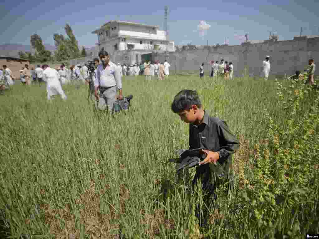 Pakistan - Dok su novinari i fotoreporteri okružili kuću u kojoj je ubijen Bin Laden, ovaj dječak je odlučio da sakupi ostatke od pucnjave predhodne noći, Abbottabad, 03.05.2011. Foto: Reuters / Akhtar Soomro