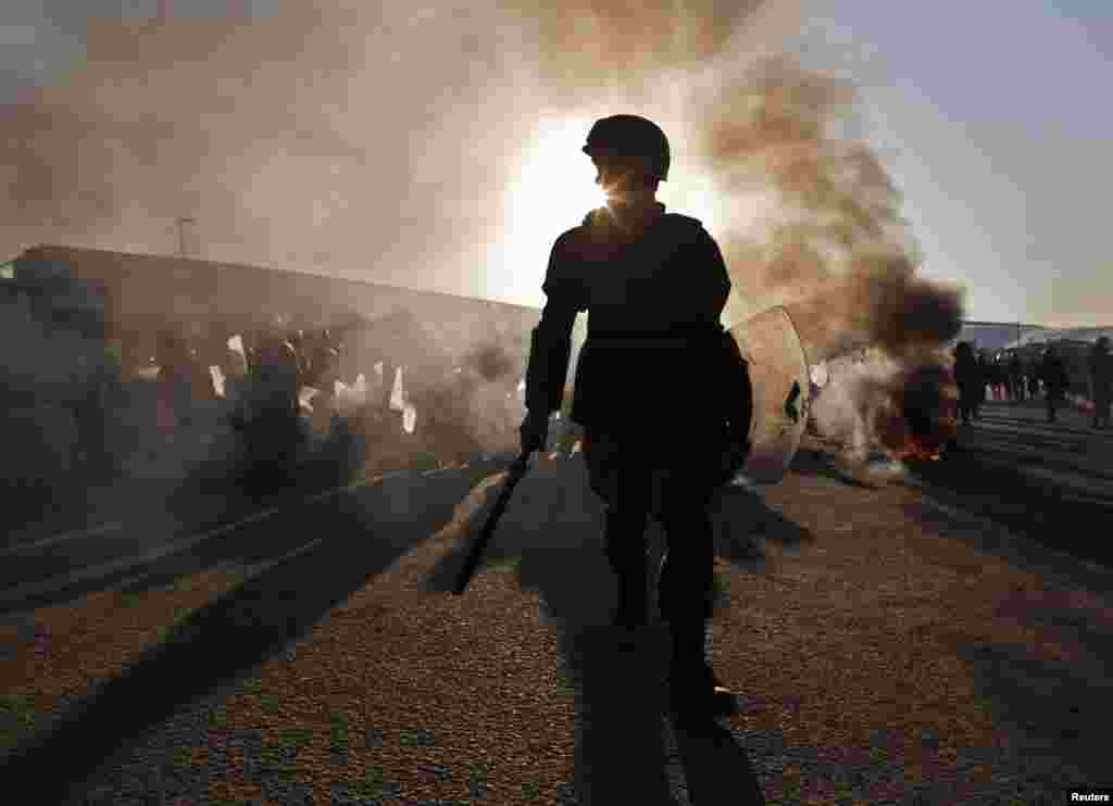 A policeman patrols during clashes with protesters in Kabul on February 24 angry over the burning by ISAF forces of the Koran. (REUTERS/Ahmad Masood)