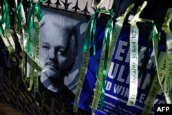 Un banner plasat de un susținător al fondatorului WikiLeaks, Julian Assange, este ilustrat pe balustrada din fața Înaltei Curți de la Londra, la 20 mai 2024.