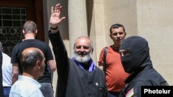 Armenia - Archbishop Bagrat Galstanian waves to supporters as he is arrested in Yerevan, June 25, 2025.
