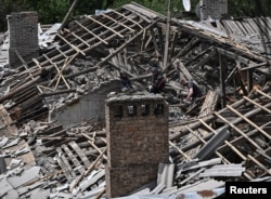 Ukrajinski spasioci rade na lokaciji stambene zgrade pogođene ruskim napadom drona u Zaporožju 30. maja.