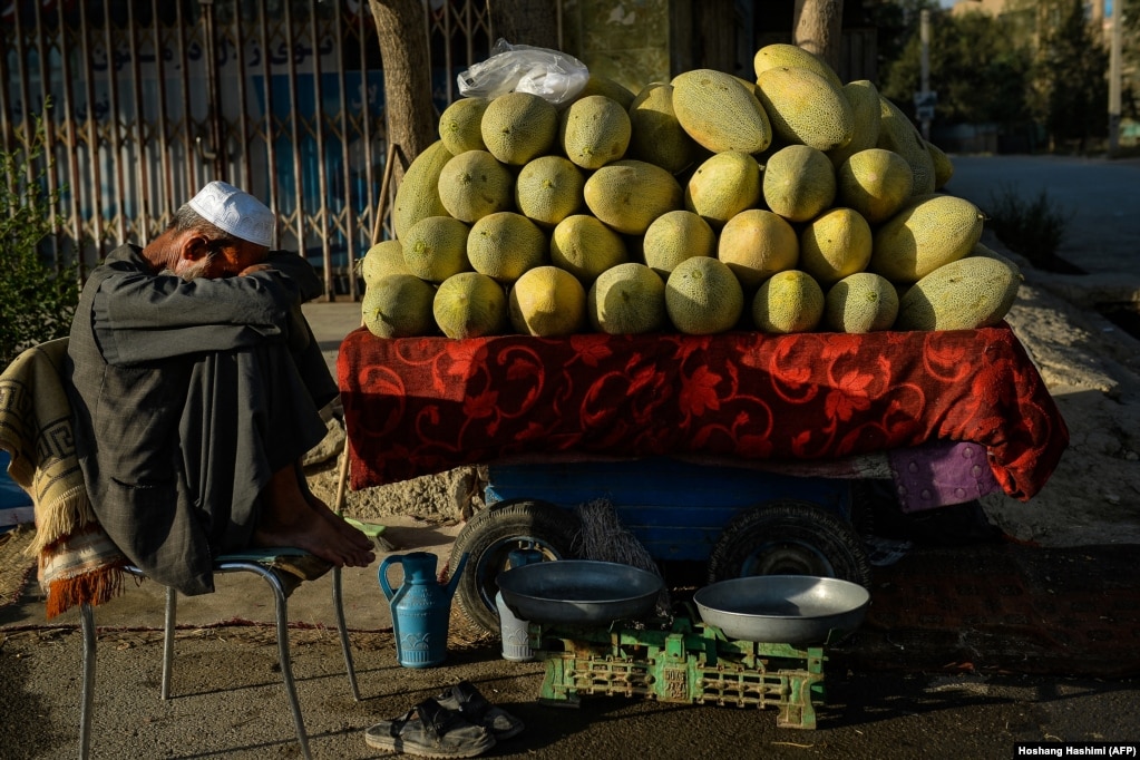 An Afghan fruit vendor waits for customers along a street in Kabul.