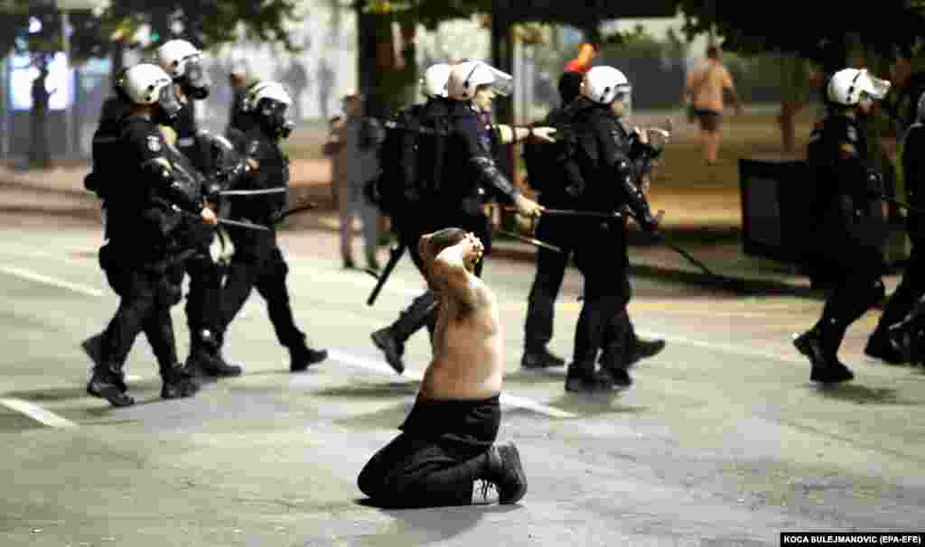 A man kneels during protesters&#39; clashes with police outside the Serbian Parliament building in Belgrade on July 7. (epa-EFE/Koca Sulejmanovic)