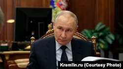 Уладзімір Пуцін, ззаду кветка з пажоўклым лістом, 6 лютага 2026 г.