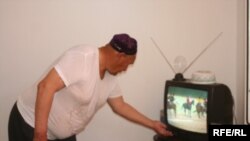 Жаңа үйге көшіп келген тұрғын теледидарды қосып жатыр. Алматы, 11 шілде 2009 жыл. (Көрнекі сурет)