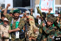 Fighters loyal to Yemen's Houthi rebels shout slogans during a rally to recruit more fighters in Sanaa on September 10.