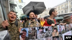Militari și activiști ucraineni din comunitatea LGBT poartă un banner cu fotografiile celor căzuți pe câmpul de luptă, în timpul marșului „Kyiv Pride 2024” din 16 iunie.