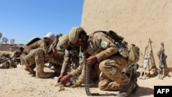 Afghan National Army commandos load their rifles during a battle with Taliban militants in Helmand province, where the group has a strong presence.