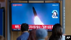 Qytetarët në Seul duke shikuar lajmet për raketën e lëshuar nga Koreja e Veriut. 4 tetor 2022.