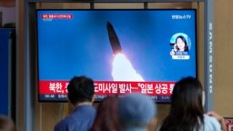 Qytetarët në Seul duke shikuar lajmet për raketën e lëshuar nga Koreja e Veriut. 4 tetor 2022.