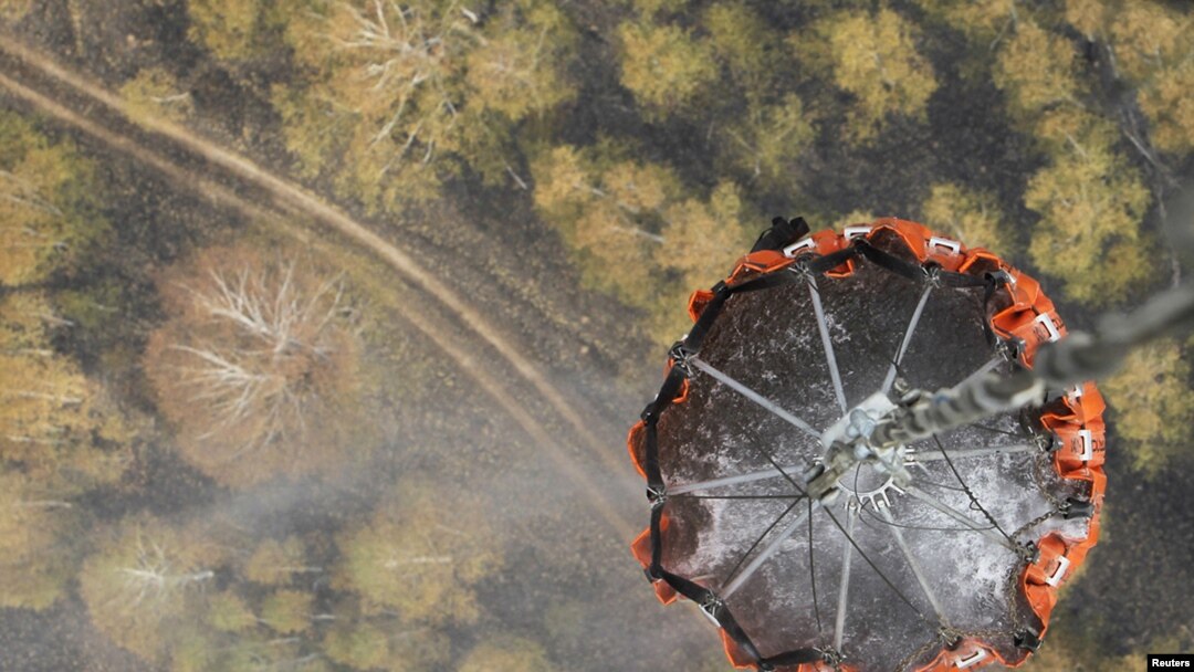 A helicopter carries water before releasing it over a forest fire in central Russia on August 10.