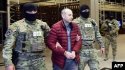 Russian-Israeli blogger Aleksandr Lapshin is escorted upon his landing in Baku after being extradited from Belarus on February 7.