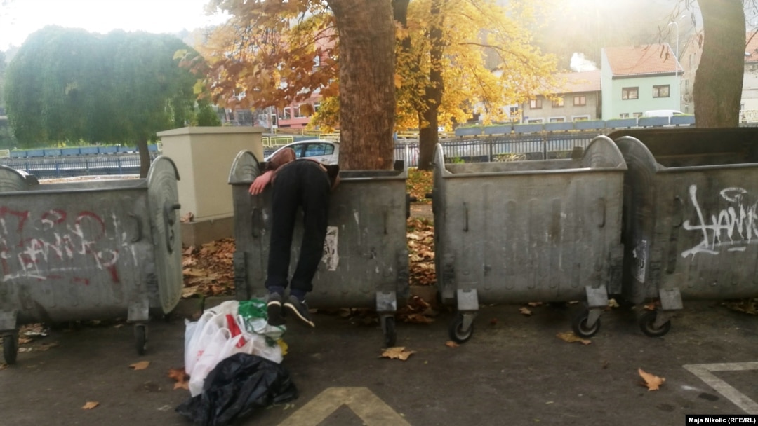 Mulți dintre oamenii străzii se hrănesc cu ceea ce aruncă alții. În imagine, un bărbat din Kîrghistan care scotocește într-o pubelă pentru a găsi de-ale gurii 