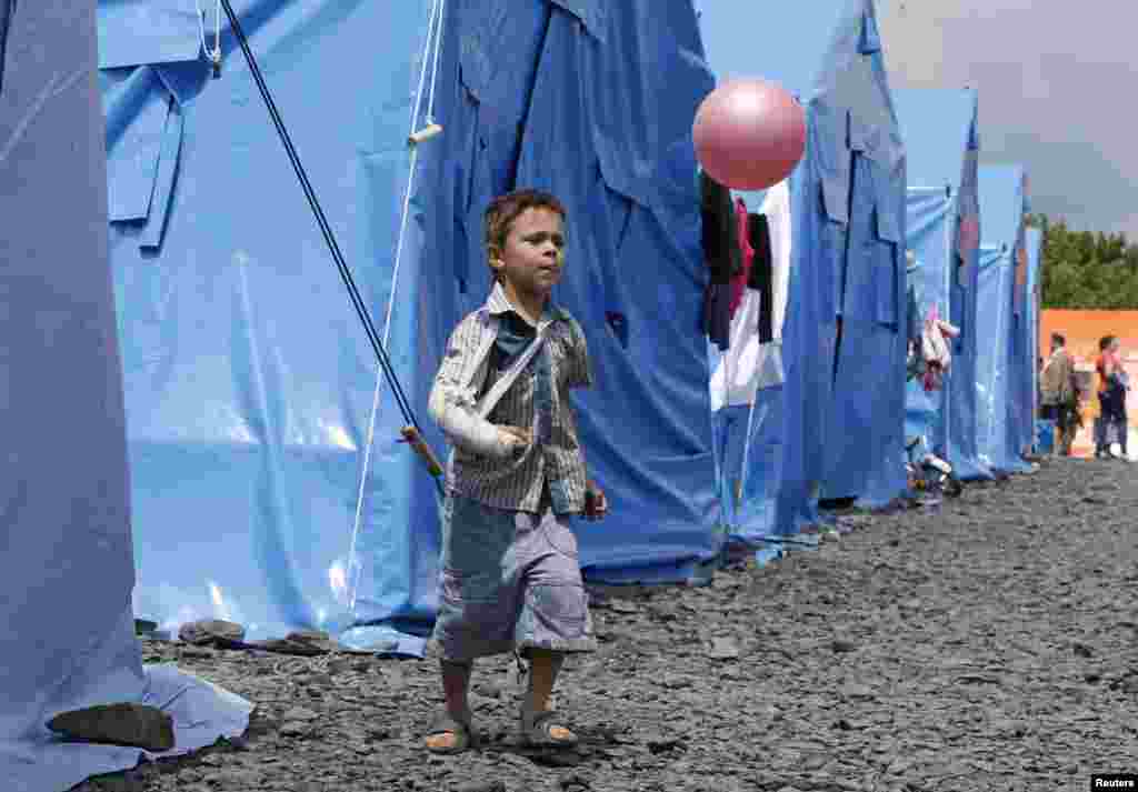 A boy plays with a ball at a temporary tent camp set up for Ukrainian refugees in the town of Novoshakhtinsk in Russia&#39;s Rostov region near the Russian-Ukrainian border on July 9. (Reuters/Sergei Karpukhin)