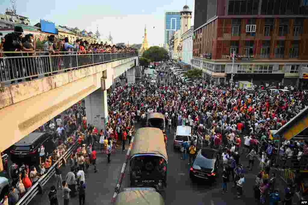 Mașinile de poliție își fac loc printre manifestanți&nbsp; (Photo by YE AUNG THU / AFP)