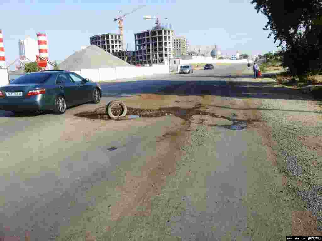 Asfaltyň aşagyndan suw çykyp duran Aşgabadyň köçeleriniň biri.