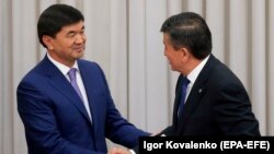 New Prime Minister Mukhammetkalyi Abylgaziev (left) is congratulated by President Sooronbai Jeenbekov in parliament in Bishkek on April 25.