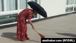 turkmenistan. woman with brooms are cleaning streets ahead of Elder's Council in Turkmenabat