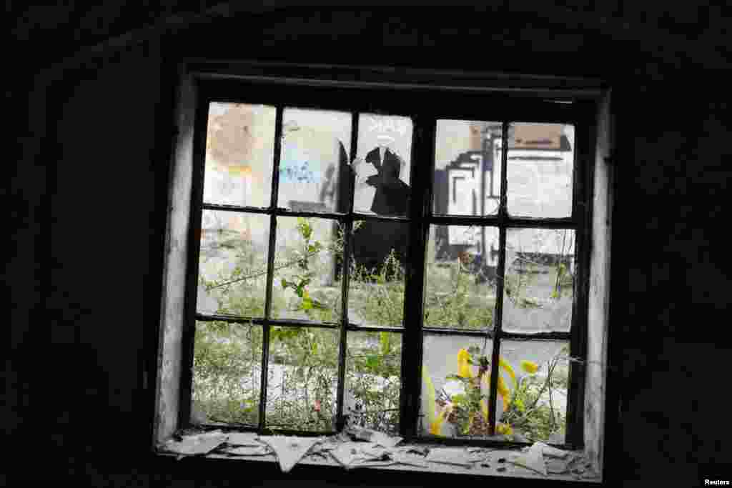 A broken window in one of the buildings at Topovske Supe, the site of a concentration camp from August 1941 to December 1942.