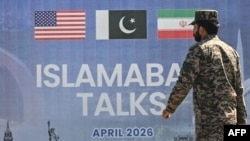Un soldat pakistanez din trupele de rangers trece pe lângă un panou cu negocierile de pace dintre SUA și Iran, la Islamabad, pe 12 aprilie 2026.