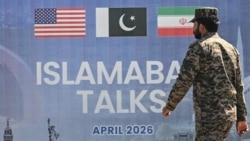 A Pakistani Ranger walks past a billboard for the US-Iran peace talks in Islamabad on April 12.