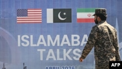 یک سرباز پاکستانی در حال عبور از کنار بیلبوردی مربوط به مذاکرات صلح امریکا و ایران در اسلام آباد