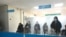 Наблюдатели у стеклянной перегородки на избирательном участке в Астане в день парламентских выборов. 10 января 2021 года