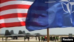 Литва – Флаги США и НАТО перед истребителями ВВС США F-22 Raptor на авиабазе в Шяуляе.