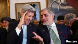 U.S. Secretary of State John Kerry speaks with Afghanistan's Chief Executive Abdullah Abdullah (R) during the Conference on Afghanistan in London on December 4.