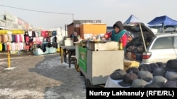 "Ақ бұлақ" базарының сыртында ыстық самса мен сусын сатып тұрған әйел. Алматы, 24 желтоқсан 2020 жыл.