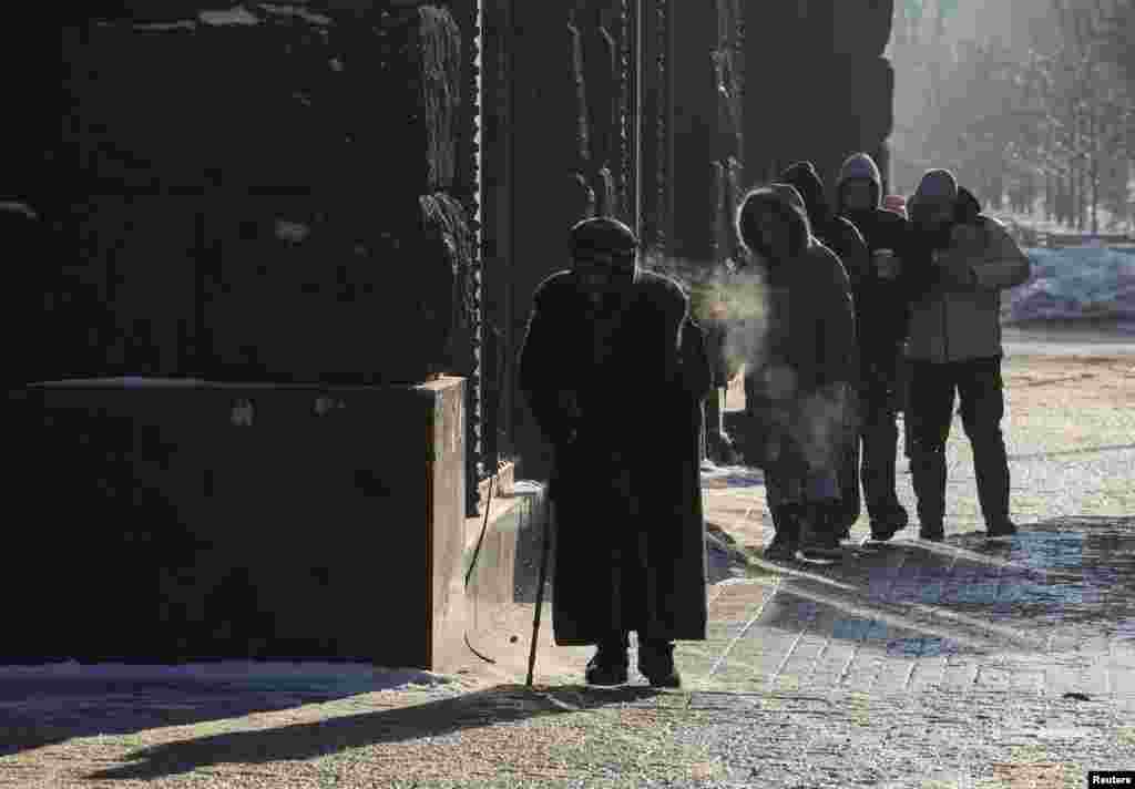 Oameni îmbrăcați gros, pe o stradă din Kiev, pe 16 ianuarie.