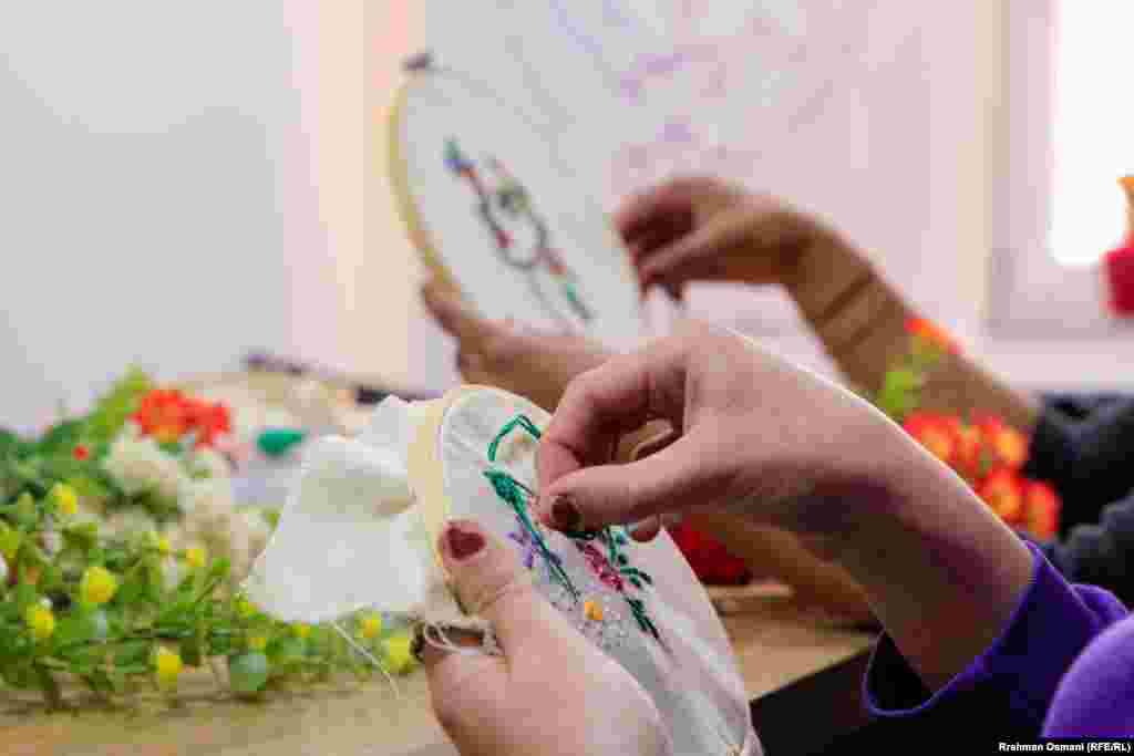 U Centru za zaštitu žena i djece u Prištini, nekoliko žena koje su preživjele nasilje u porodici veze različite uzorke na tkanini.