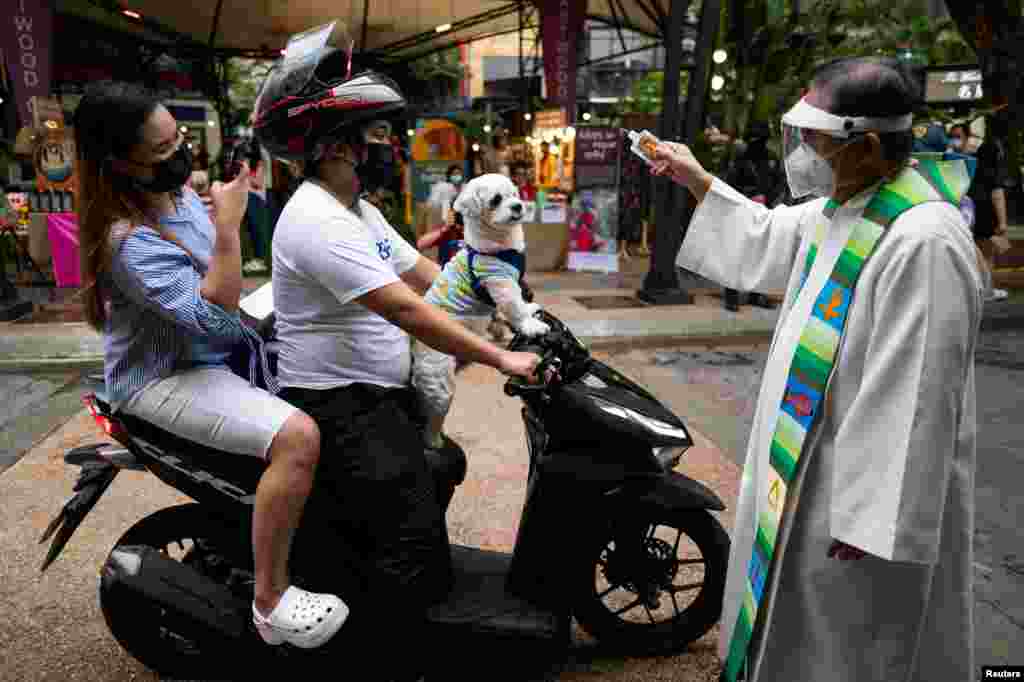 Священник освячує собаку, який через обмеження у зв&#39;язку з коронавірусом приїхав на мотоциклі.&nbsp;Кесон-Сіті, Філіппіни, 3 жовтня, 2021 року