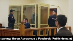 Константин Окунев (за стеклом) в зале суда. Фото: Игорь Аверкиев. 2025 год