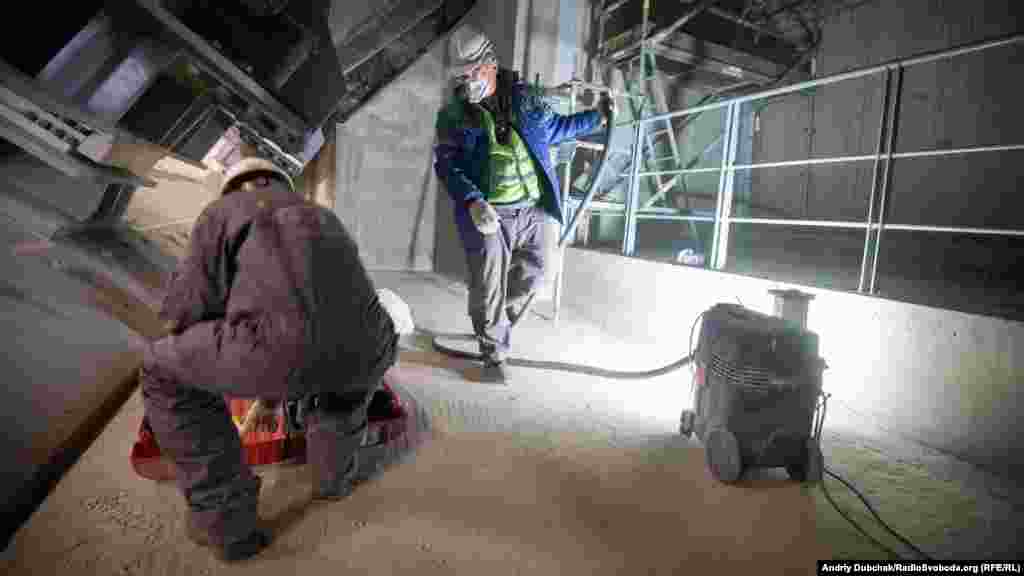 Рабочие внутри НБК шлифуют стыки бетонных подушек. Внутри саркофага довольно пыльно, но уровень радиации относительно низок. Власти заявляют, что угрозы здоровью рабочих нет.&nbsp; &nbsp;