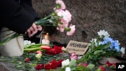 Луѓето положуваат цвеќе за да ја одбележат смртта на опозицискиот лидер Алексеј Навални на споменикот на жртвите на политичката репресија во Советскиот Сојуз, Москва, 17 февруари 2024 