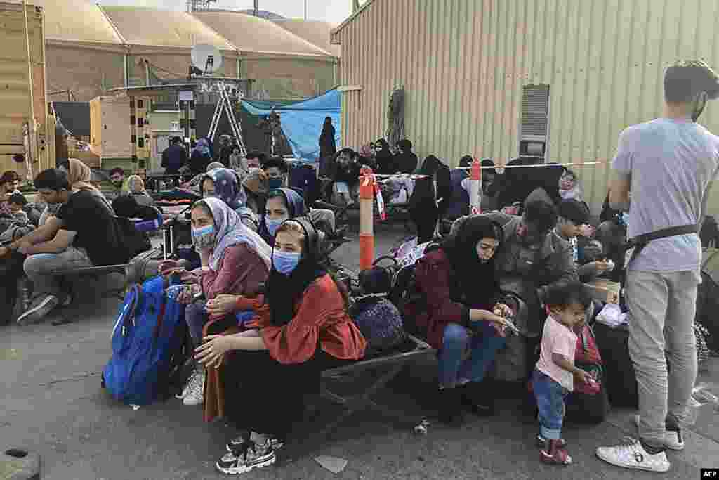 Hundreds of Afghans continue to gather at Kabul airport on August 18, waiting to be evacuated.