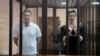 Maksim Znak (left) and Maryya Kalesnikava stand inside a defendants' cage as they attend a court hearing in Minsk on September 6.