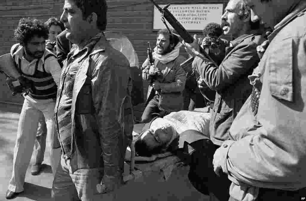 A shooting victim is carried away from the U.S. Embassy by armed men loyal to&nbsp;Ayatollah Khomeini after they had stormed the compound.