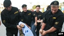 Riot police detain an opposition supporter in Minsk during a protest against Belarus and Russia military exercises in September 2009.