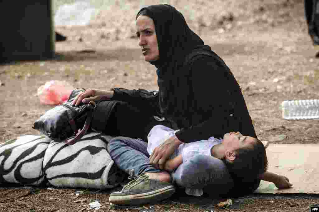 A child rests on the knees of a woman in a refugee center in Presevo, Serbia. (AFP/Armend Nimani)