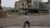 A resident walks past a ruined building in the embattled Ukrainian city of Pokrovsk. 