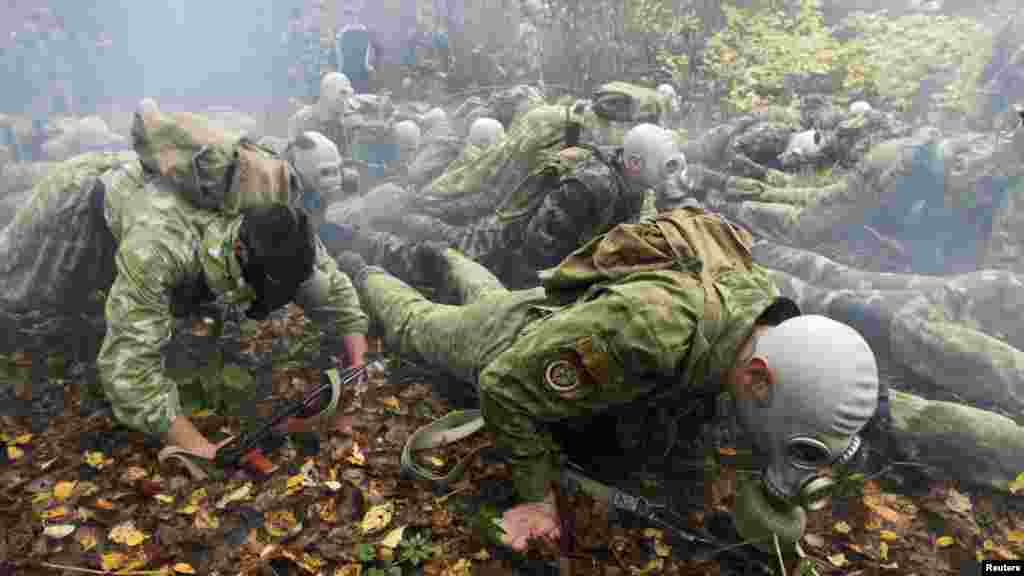 Servicemen from a Belarusian Interior Ministry special unit wear gas masks and crawl on the ground during a test near the village of Horany. (Reuters/Vasily Fedosenko)