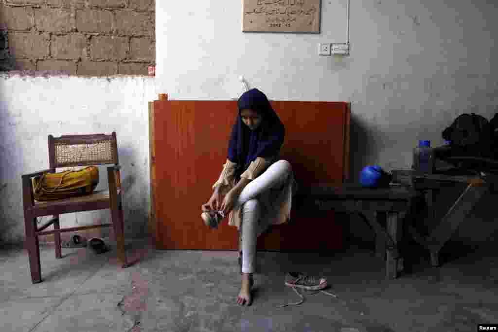 Tabia, 12, removes her shoes after finishing a training session.