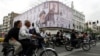 People ride motorcycles in Tehran on May 5 near a billboard featuring an image of the late Supreme Leader Ayatollah Ali Khamenei. 